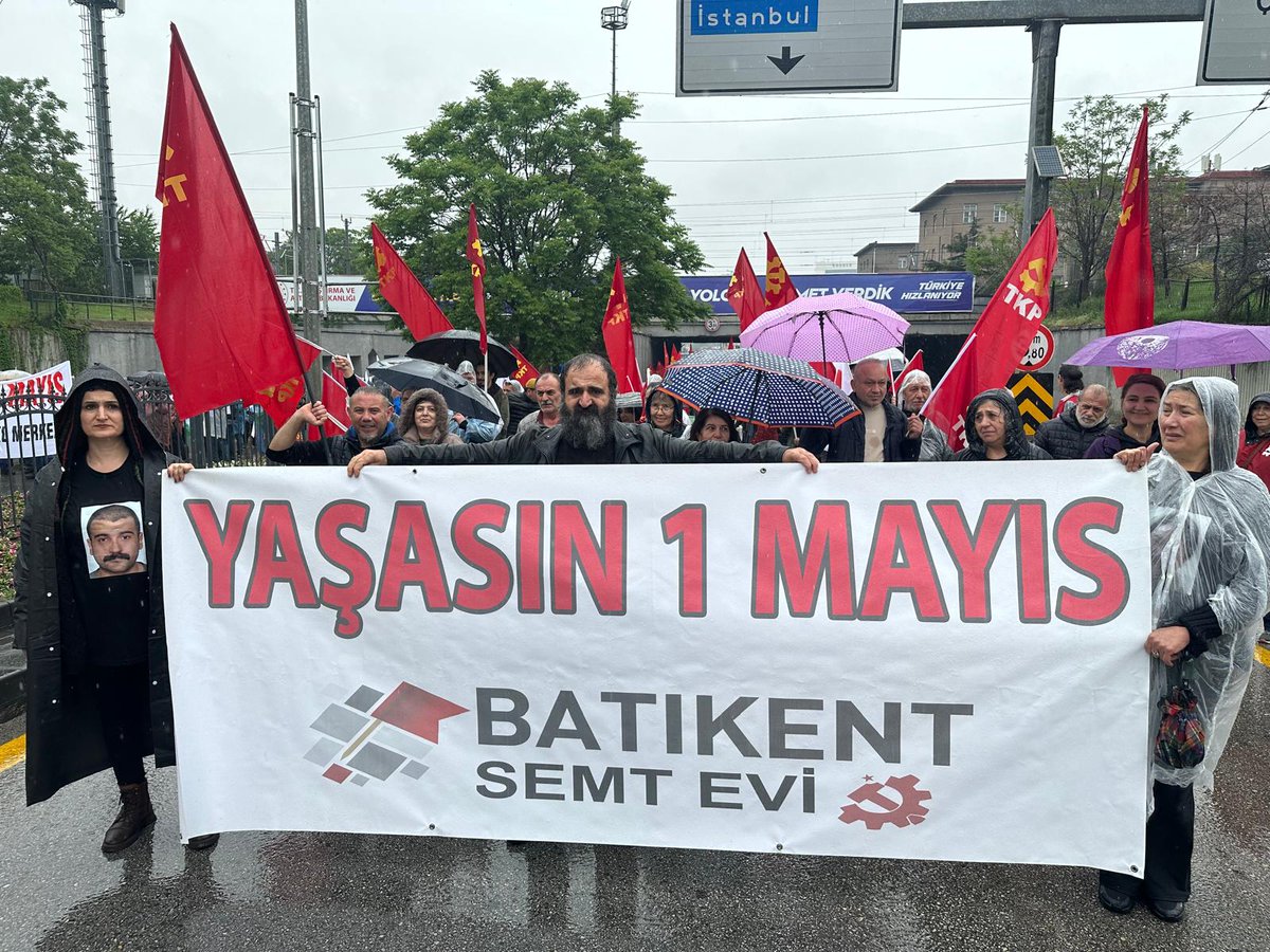 Gelin 1 Mayıs bahanesi ile hız düşkünü patron çocuğunun, genç bir emekçiyi nasıl katlettiğini hatırlayalım. Hem de bir 1 Mayıs pankartıyla yapalım bunu. Yıl 2023. 1 Mayıs pankartı. Sol taraftaki fotoğraf. Kollarını açan bir genç emekçi. Ve bu senenin 1 Mayıs pankartı. Sağ…