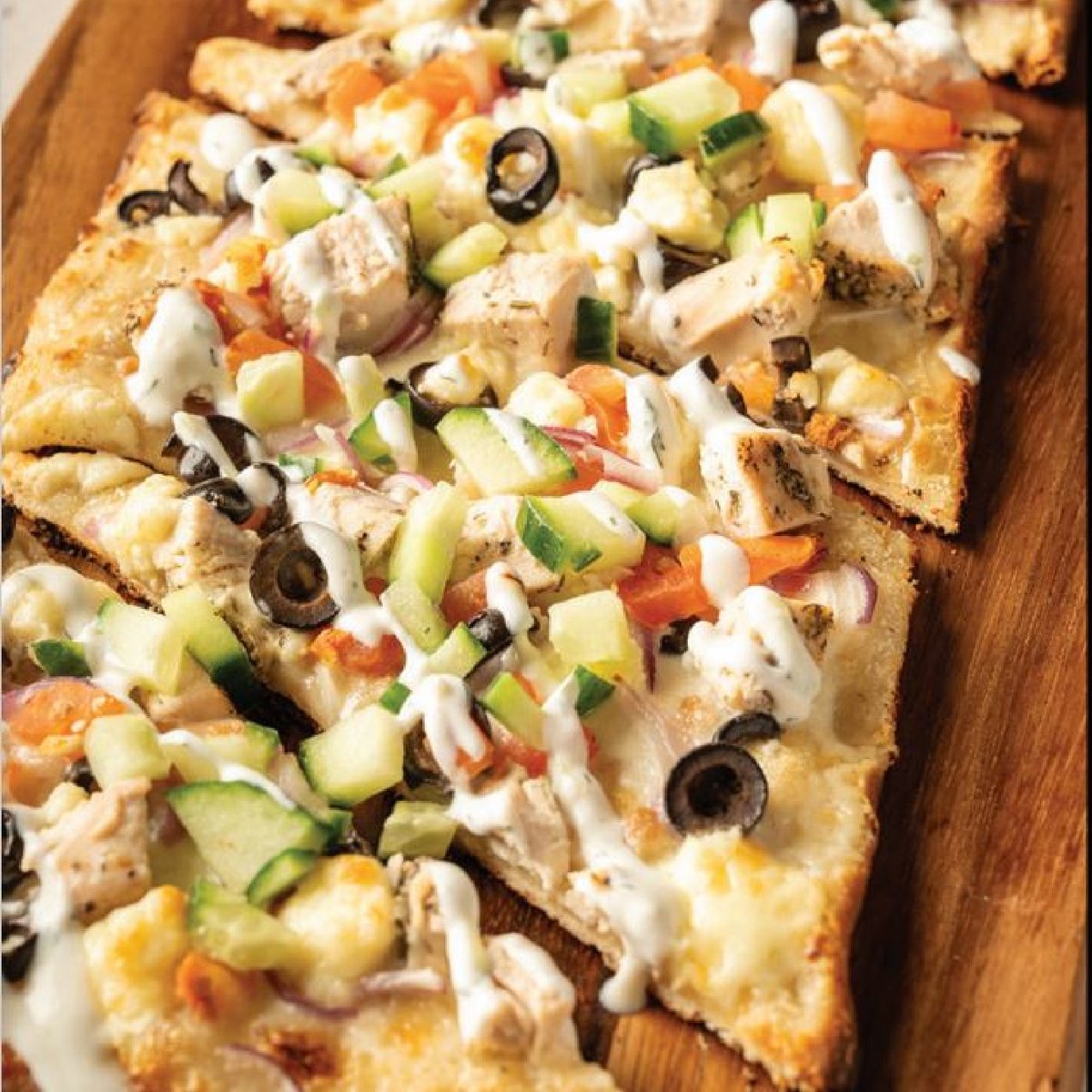 Our May special for Draft Day is Greek Chicken Flatbread. This pizza is topped with red onion, cucumbers, tomatoes, chicken, olives, feta, at tzatziki sauce. #RiversideCasino #EliteCasinoResorts #Iowa