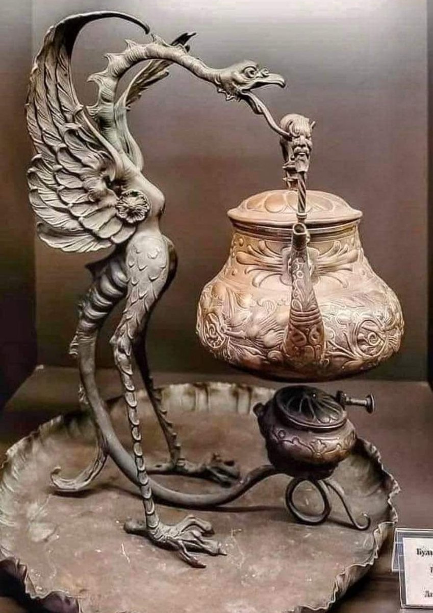 A basilisk (a legendary reptile reputed to be a serpent king) keeps watch over this Russian spirit kettle that's from the mid-19th Century CE. A spirit kettle - a teapot that sits on a stand and has an alcohol burner beneath it - gets its name from the fact that spirits were…