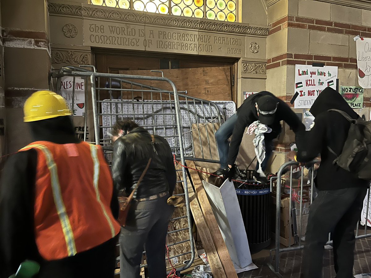 Appears likely that police action is imminent. People are lined up facing Royce Hall, seemingly in anticipation of police coming from the ends. A sniper is on top of the bldg & protestors are reinforcing door barricades. One protester said cops are in the bldg