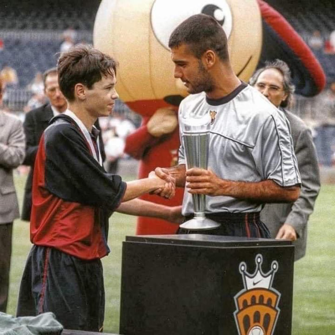 A very young Andrés Iniesta accepting an award from Pep Guardiola.