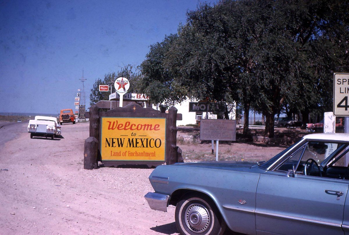 This is a Kodak color film photo of the New Mexico border at Glenrio, Texas looking into New Mexico with the iconic State Line Bar Texaco service station in the background. Under the Motel sign is a 'Will Rogers Highway' official dedication sign for Route 66. We would appreciate