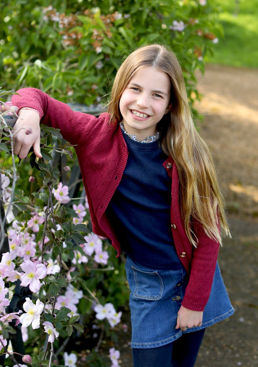 🎉 📸 A new portrait of Princess Charlotte has been released to mark her 9th Birthday. The photograph was taken by The Princess of Wales in the last few days. Charlotte is seen casually posing outside next to a clematis plant with pink petals.