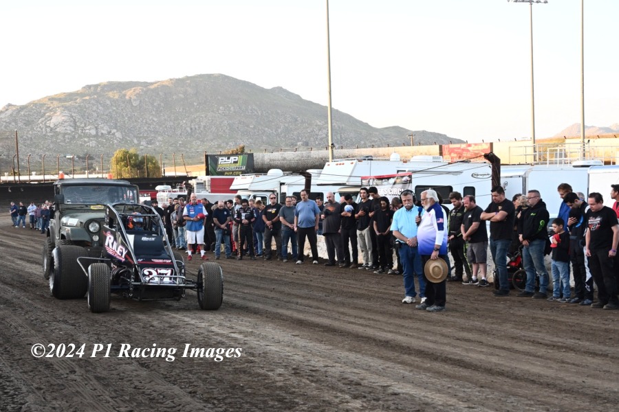 Drivers, crews, and officials gather on the front straightaway at Perris Auto Speedway last Saturday to honor “Brother” Brett Taylor as Matt Mitchell is set to perform memorial laps. A.J. Johnson / P1 Racing Images. #USAC #USAC410 #usacnation #usacracing #usaccra #usacsprints