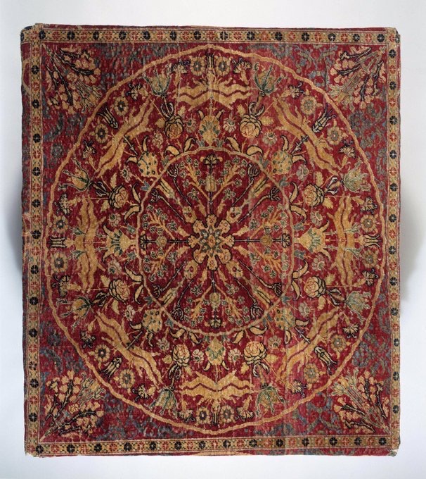 Table carpet woven in cruciform shape, medallion design with Ottoman floral motifs on red ground, probably made in Ottoman Cairo, 1550-1600. (Victoria and Albert Museum, London)