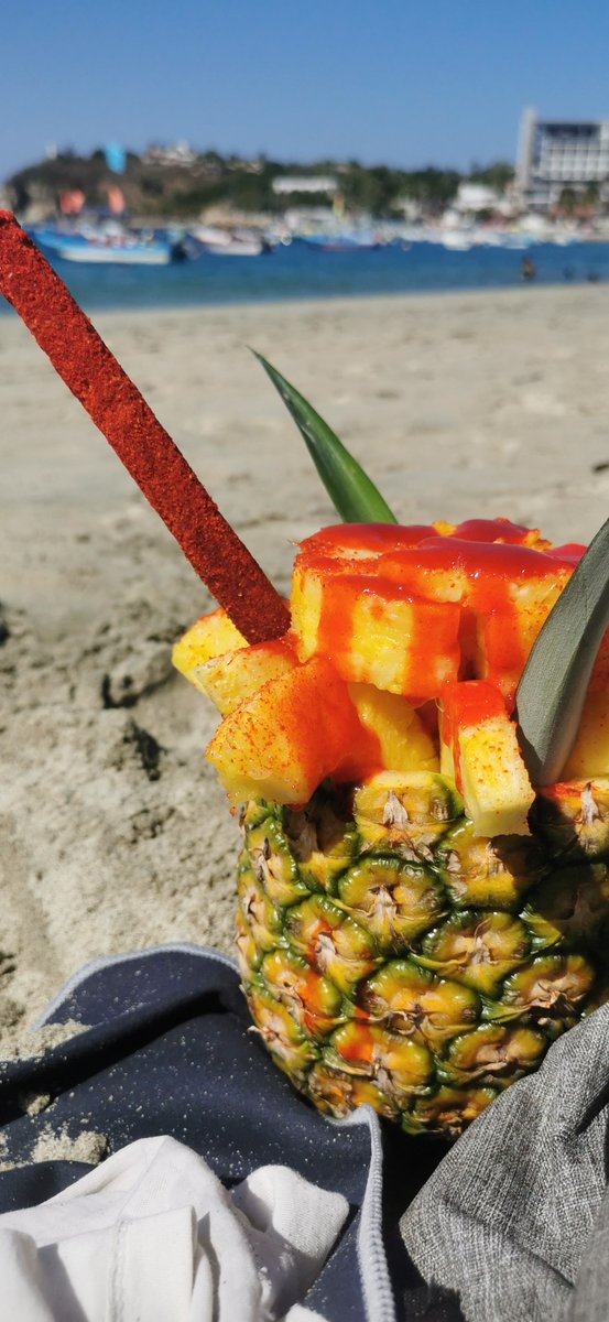 Pineapple with chamoy on the beach is how we do it in Mexico. Sweet, salty, sour, spicy, and sandy. 🍍🌶️ Have you tried this tangy twist on tropical? #MexicanFood #MexicoTravel #PineappleChamoy #TasteofMexico
