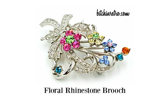 Floral #brooch with delicate pave set #rhinestones which grace the ribbons & leaves. Rhinestone #flowers are set in a descending fashion creating dimension while others represent buds of future flowers. #mothersdaygiftideas #mothersdaygifts #bitchinretro bitchinretro.com/products/rhine…