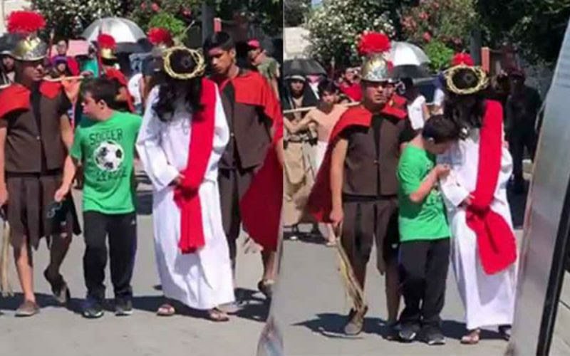 A boy with down syndrome comes up to an actor playing Jesus in a Viacrucis (Way of the Cross) procession in Mexico to comfort him.