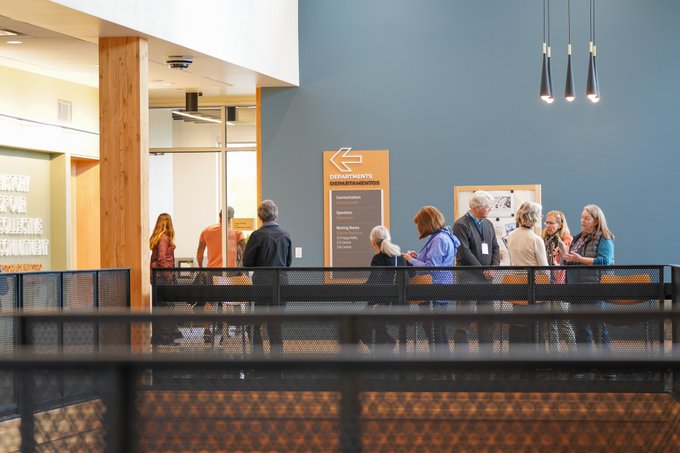 Visitors have conversation in a common space balcony area of the upper level at the new district office