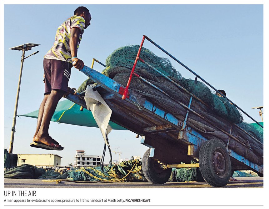 UP IN THE AIR A man appears to levitate as he applies pressure to lift his #handcart at #MadhJetty. Photo: @DAVENIMESH for @mid_day