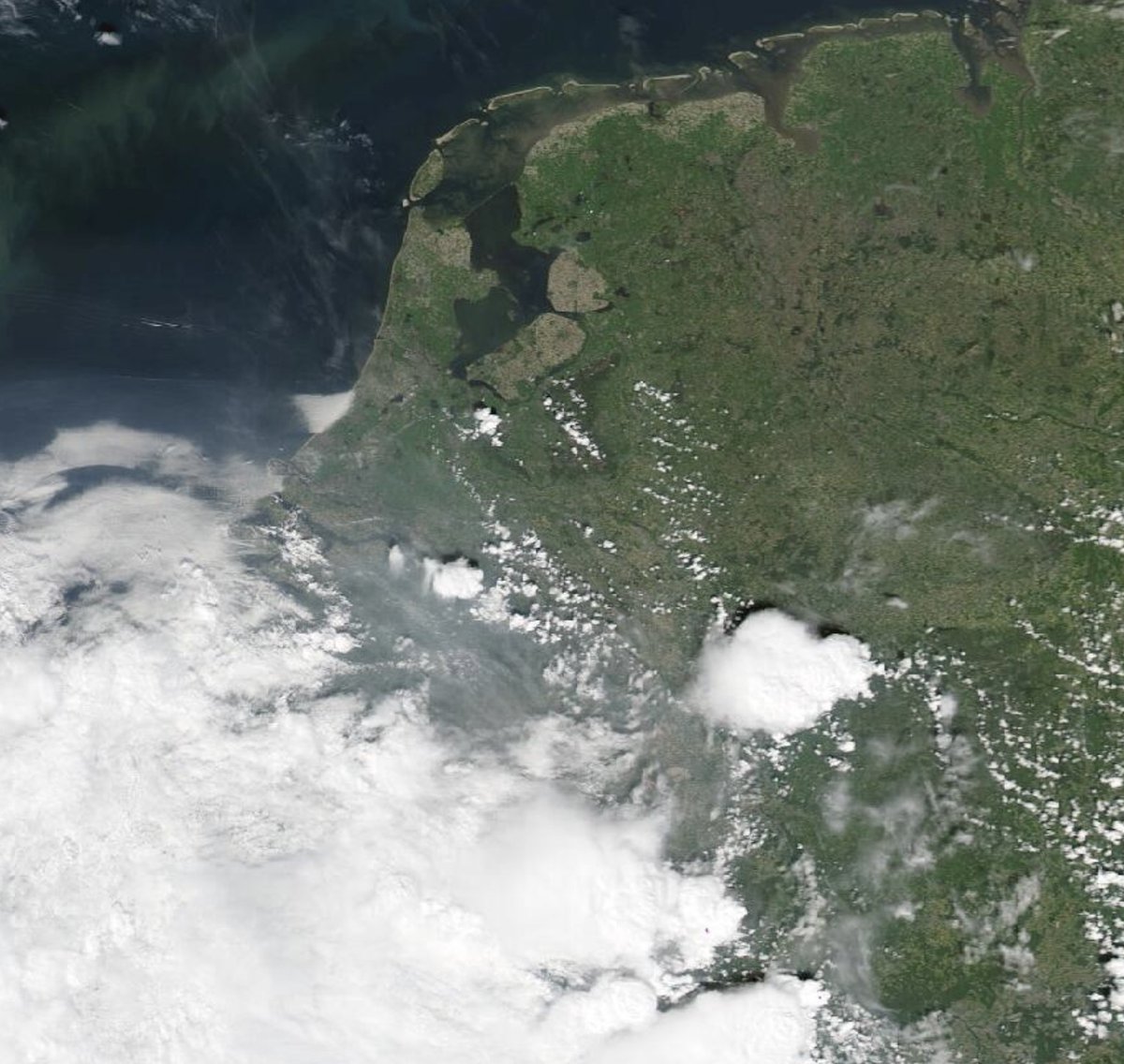 Fraai satellietbeeld van gistermiddag, waarop de eerste buien zichtbaar zijn in de buurt van Tilburg en Düsseldorf. Iets later (hier nog niks van te zien) ontstond er een zware bui precies boven Eindhoven. Bron: NASA