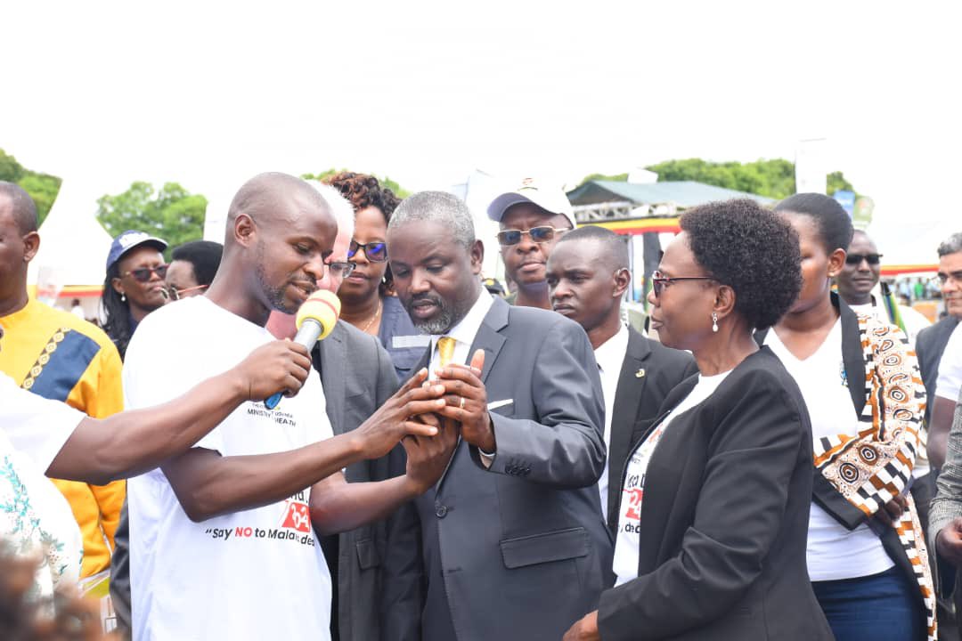 A VHT member in Kibuku District demonstrates the smart phone based application to Deputy Speaker, @Thomas_Tayebwa for registering households for receiving mosquito nets