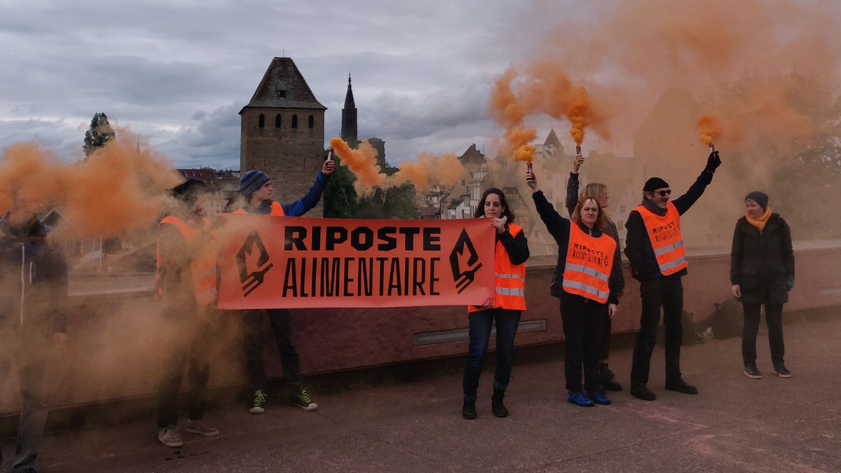 🦺 ACTION EN COURS - Strasbourg 3 mai 2024, 10 citoyennes et citoyens engagés dans la campagne Riposte Alimentaire ont allumé des fumigènes au barrage Vauban à Strasbourg. #A22Network #RiposteAlimentaire [1]