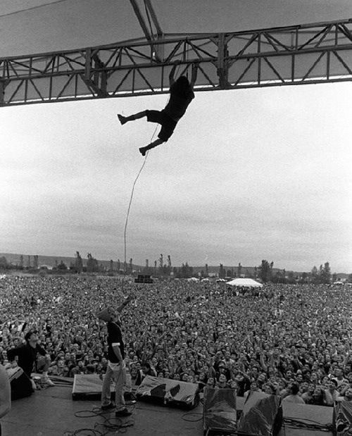 Eddie Vedder of Pearl Jam swinging from the stage rafters, 1992.