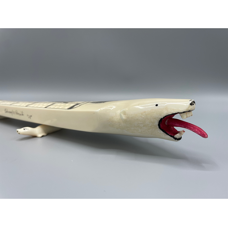 This scrimshaw cribbage board is made of whalebone, designed as a polar bear. The feet of the game are two carved whalebone seals. The top has 124 small holes for game pieces. Down the center and on each end are etchings of seals and a walrus. #ArchivesGames Object: 79.567