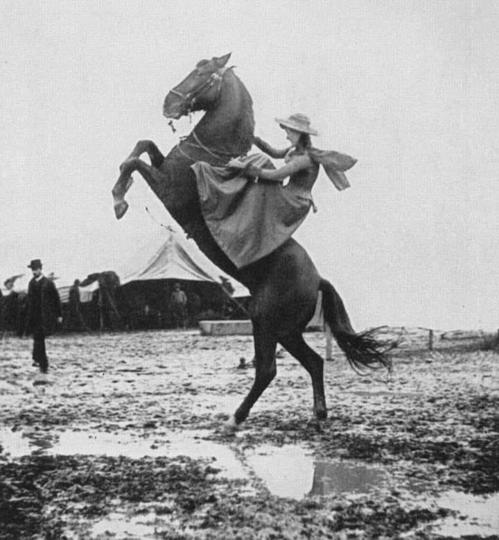 Sharpshooter Annie Oakley riding sidesaddle on rearing horse in 1890.