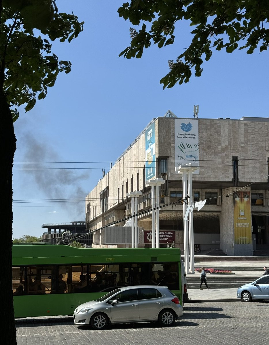 💔An ordinary day in #Kharkiv: a trolleybus continues along its route, a girl carries a cup of coffee she just bought at a nearby café, an elderly couple drives in a car along the street. Somewhere in the background, an aviation bomb explodes, and black smoke rises over the city.