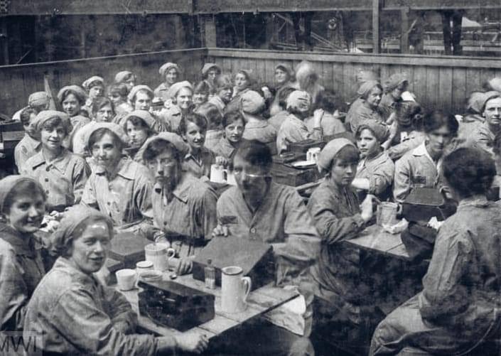 Great image of Female factory workers crowded around tables at lunchtime in a mess room in their workplace during WW1. >FH