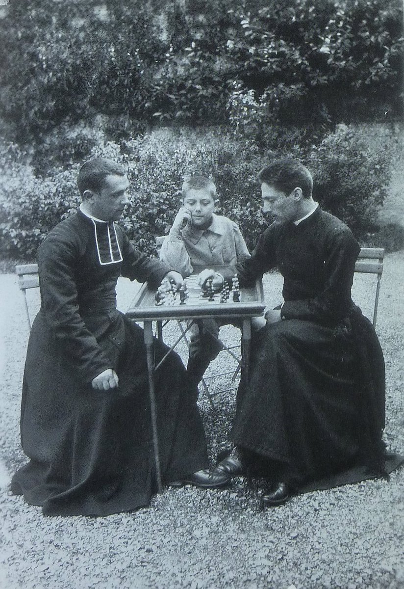 Delightful photograph of the French writer Georges Bernanos as a child watching two priests playing chess