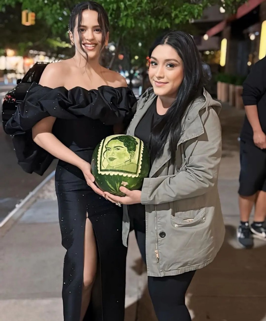 Rosalía con una fan que le regala un melón con su cara, en el evento de Tiffany Titan por Pharrell Williams en Nueva York