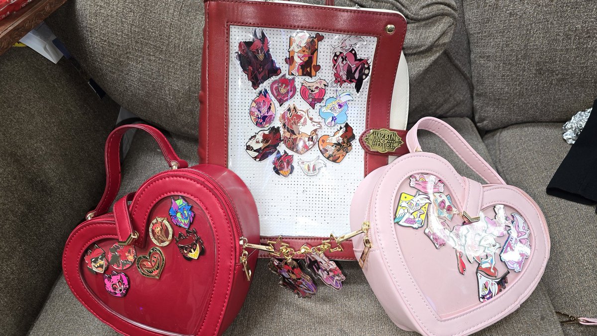 Sikamarutwin's tweet photo. So my updated #radiodust bag, I made the choice to separate into single bags all my pins that didn't have a match/pair with each character. But I'm really happy with my book bag with its new clasp. #HazbinHotel #pinbag https://t.co/46RlrUAky3