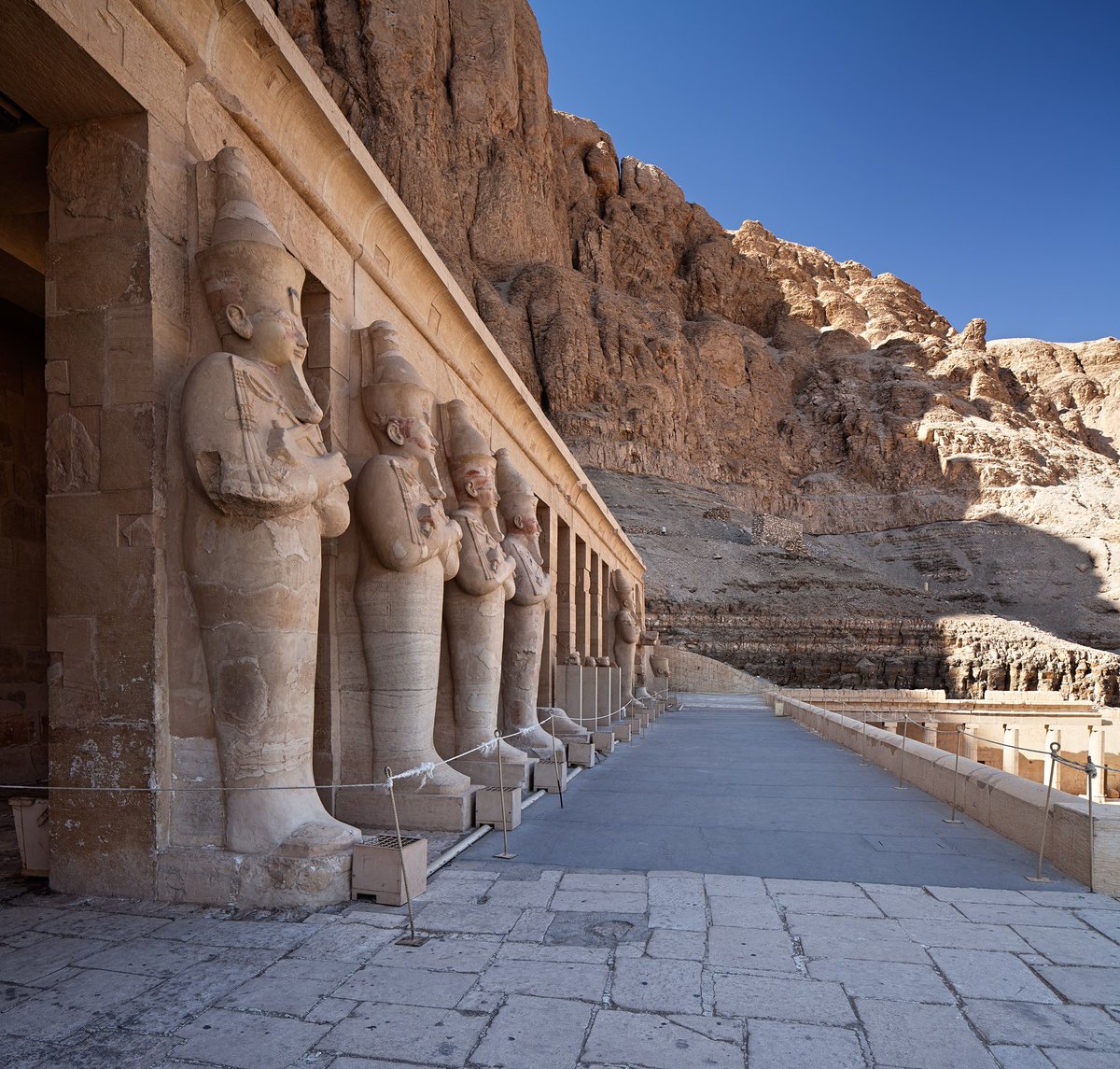 Colossal Osiride statues of the queen Hatshepsut at the entrance causeway of her temple. By Tijana Kostandovski