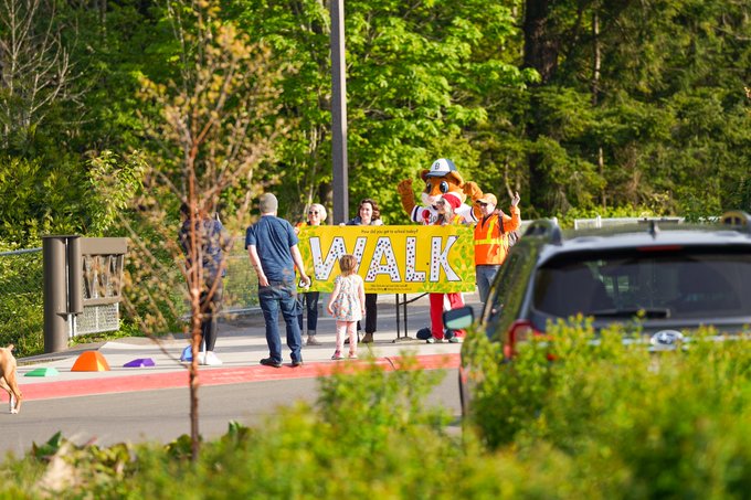 Dinger and Whatcom Smart Trips staff hold up Walk banner for a photo