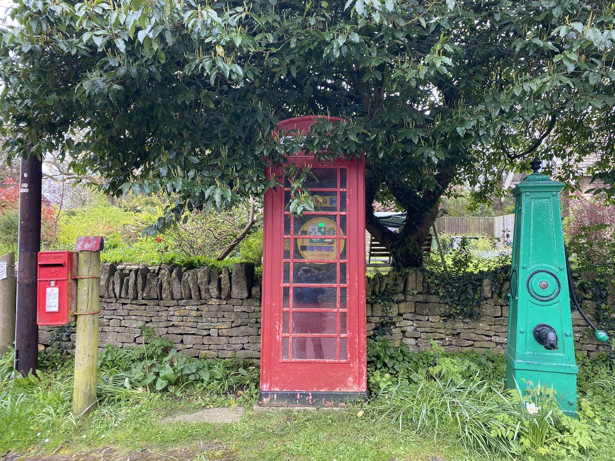 A postbox with a stylish hat on its post lines up alongside a telegraph pole, an old phonebox trying to pretend it’s not there by hiding its face in a tree, and an old-fashioned pump. It’s so obvious what’s going on here, I don’t even need to tell the story! 🤔 #PostboxSaturday
