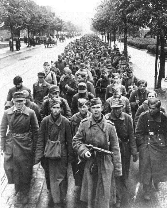 Сержант Красной Армии с пистолетом-пулеметом ППД ведет длинную колонну немецких военнопленных по улице Берлина.
Снимок сделан в берлинском районе Райниккендорф (Berlin-Reinickendorf).
Берлин, Германия
май 1945