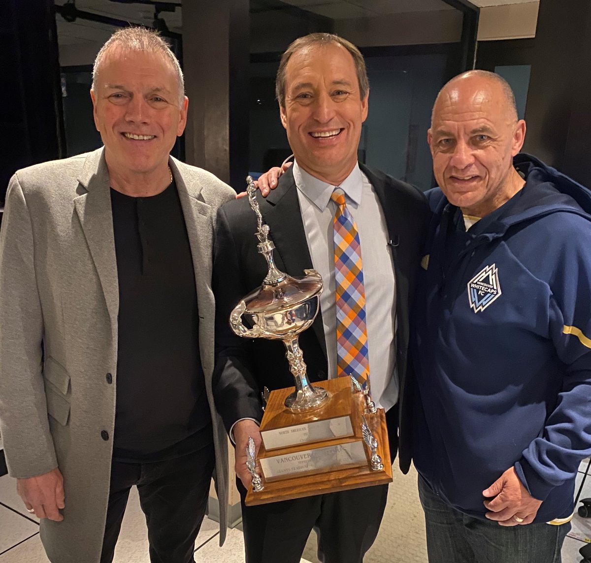 What a morning here @GlobalBC! Two Vancouver Whitecaps legends, and me in the middle proudly holding the 1979 NASL Championship Trophy. First 'Caps game 50 years ago. @WhitecapsFC @JayJanower ⚽️👍