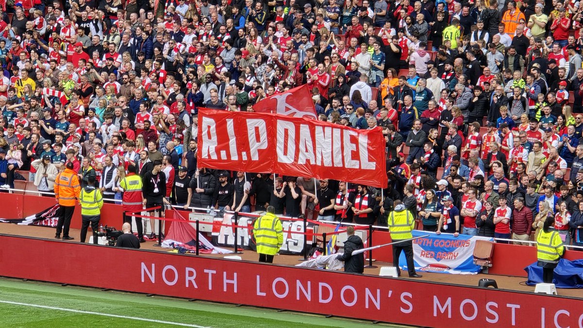 Arsenal fans once again hold up banner for Daniel Anjorin. The 14 year old was killed during the Hainault attack. The club made a tribute to the schoolboy before the game. With fans applauding on the 14th minute, during Arsenal's 3-0 victory over Bournemouth.