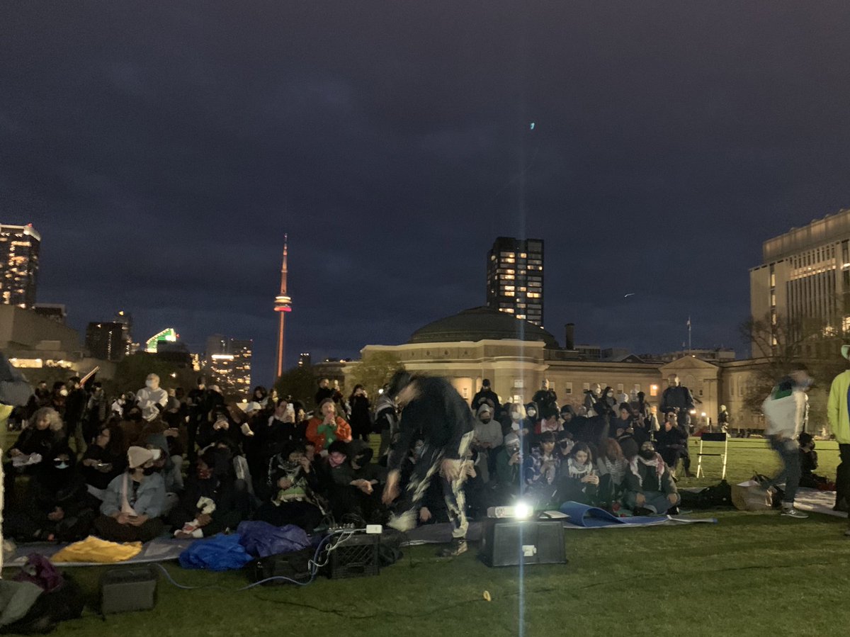 The 9th night of the #noarmsinthearts festival was always supposed to be an outdoor screening – but as a lovely surprise, the screening found a new home once the encampment sprung up at the University of Toronto. Hundreds in attendance – no amount of rain mattered