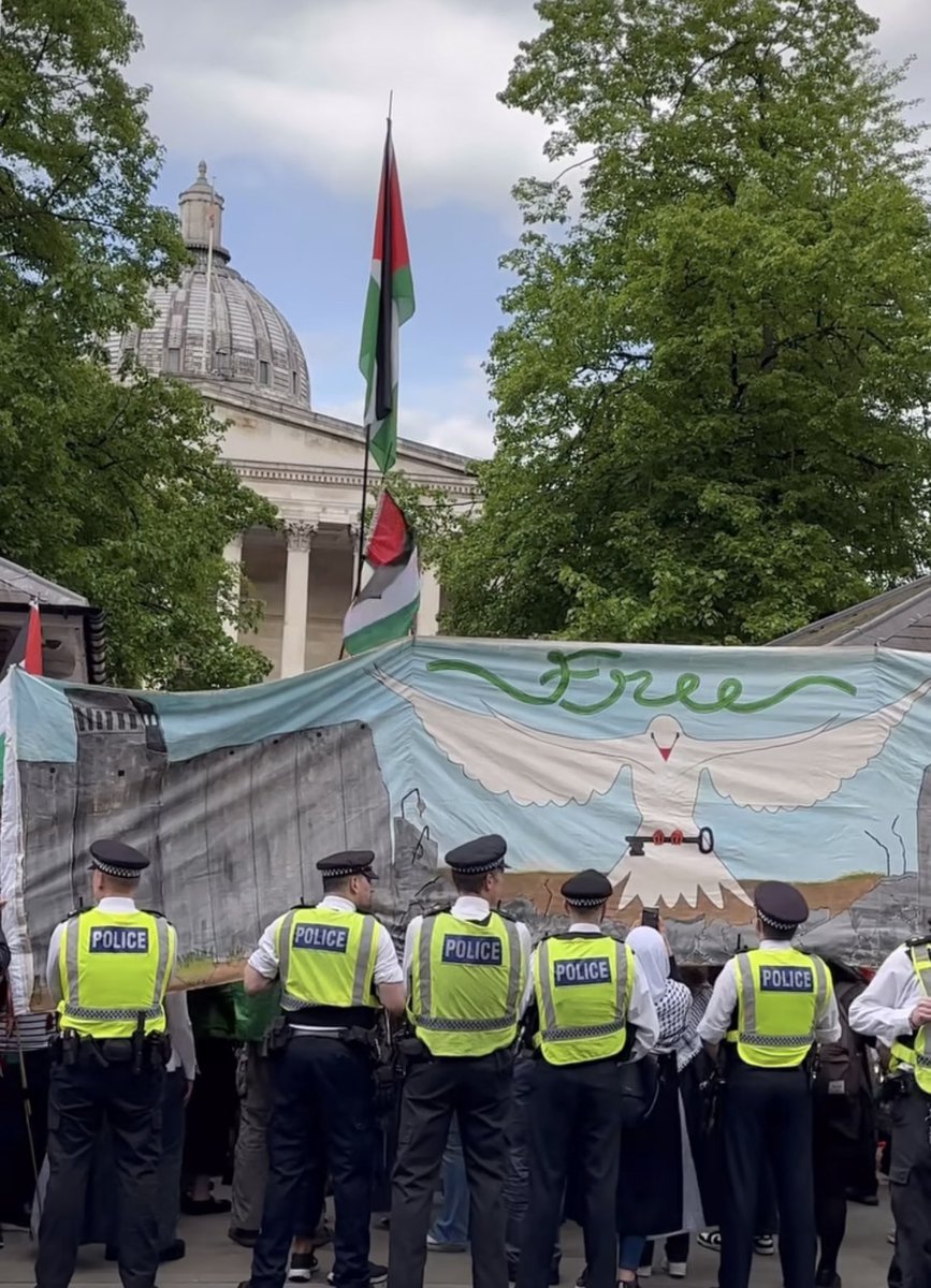 This image of protesters outside the UCL Gaza solidarity encampment today blocking the view of police with a free Palestine banner that shows the Israeli apartheid wall is just 👌👌👌 📸 @mohammadfff_