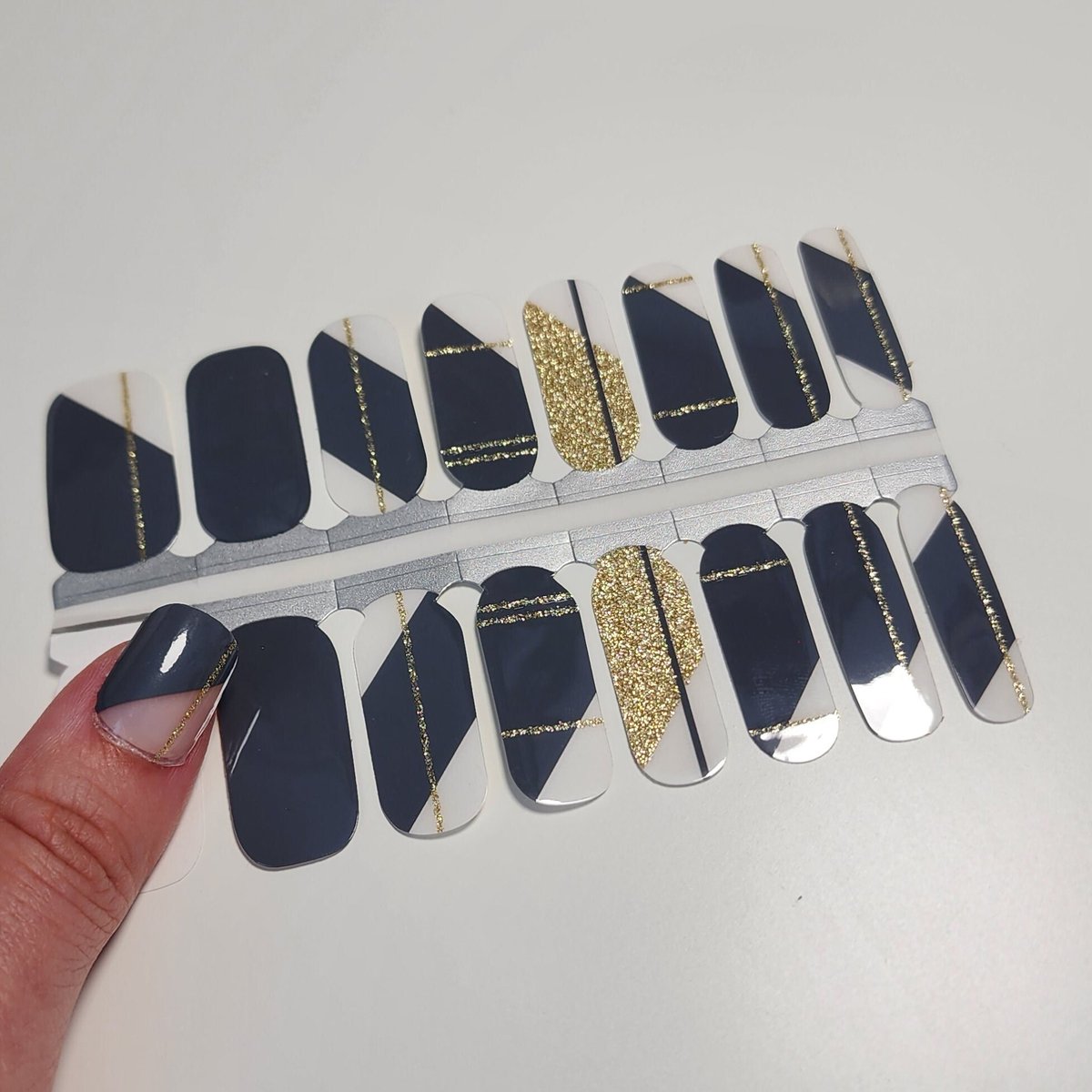 Elevate your nail game with a twist of elegance and a splash of sparkle! ✨ These Dark Grey Gold Glitter Lines Geometry Nail Wraps are the perfect touch for any occasion, from a wild party to a romantic bridal shower. 🎉💐 Say 'I do' to effortless chic and gift your bridesmaids a