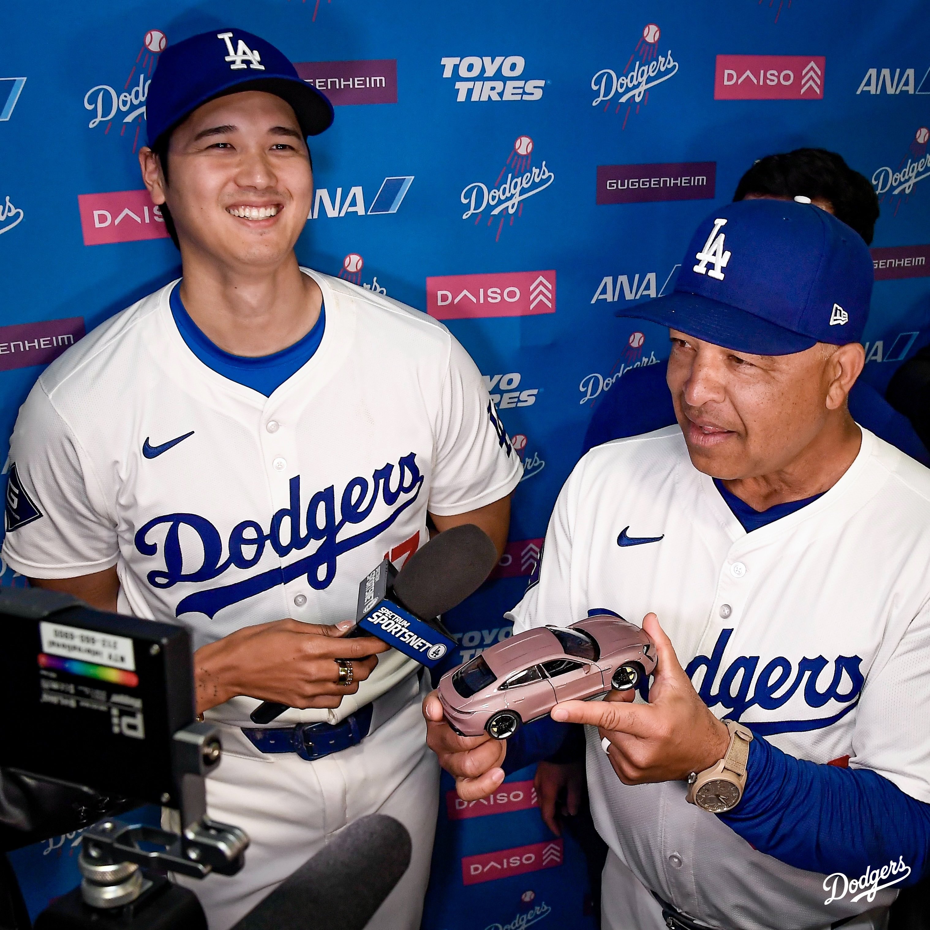 Shohei Ohtani smiles while Dave Roberts talks to the media about the toy car Shohei got him.