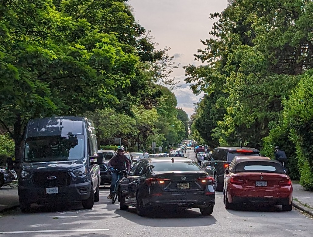 Vancouver's 'Local Street Bikeways' are such a sad joke. This is totally typical -- totally unsuitable for encouraging mode shift and safe travel. You can see a cyclist on the sidewalk on the right because the car there almost hit him while reversing to park.