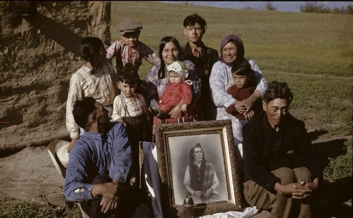 The Poundmaker family photographed at Cut Knife, Saskatchewan in 1942, with a portrait of Poundmaker and a British shell from 1885. 

📷 Everett Baker | Saskatchewan History and Folklore Society