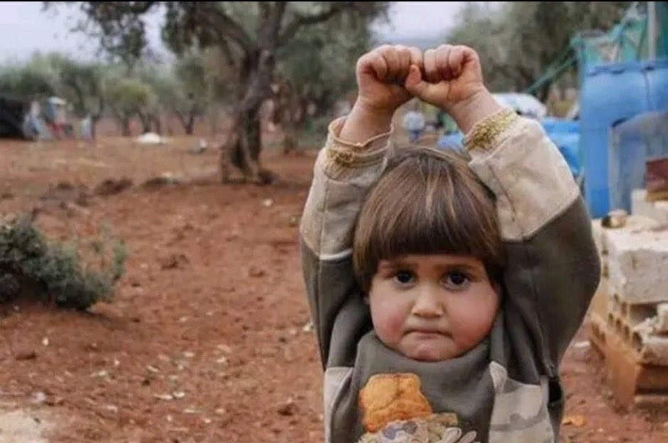 A photograph taken by Osman Sigirli in Syria in 2015 shows a four-year-old girl raising her hands in the air, mistakenly believing that the telephoto lens he was using was a gun. After the image went viral, Osman said: “I realised she was terrified after I took it, and looked at