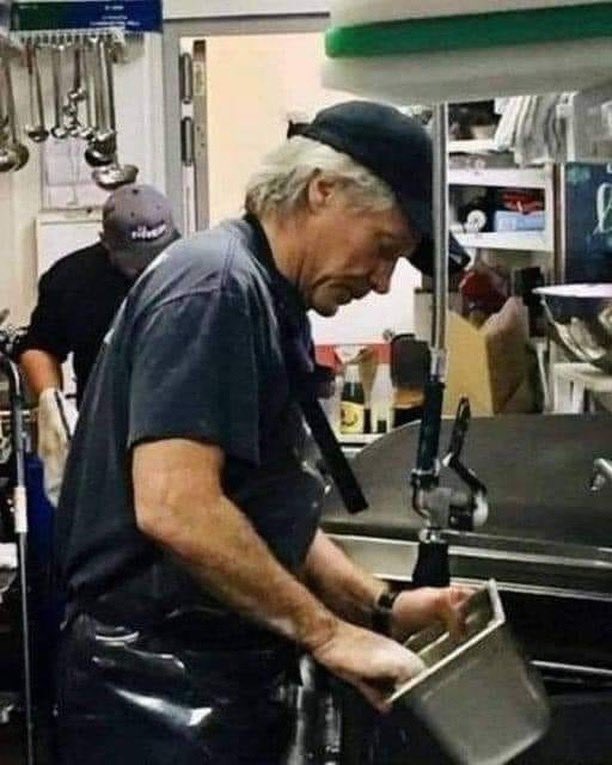Here is the singer Jon Bon Jovi and this picture is not edited. His personal wealth is 410 million dollars, and he washes trays and dishes in his Soul Kitchen restaurant chain in Newark, New Jersey, which he created for the homeless, where they can eat for free, forever. There is