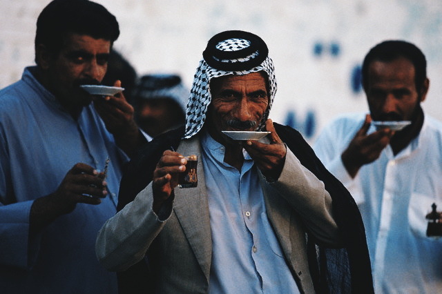 Iraqi men sip tea from saucers in a Najaf Marketplace. Najaf, Iraq. 1995.