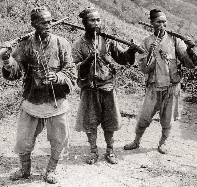Korean hunters smoking pipes in 1900.