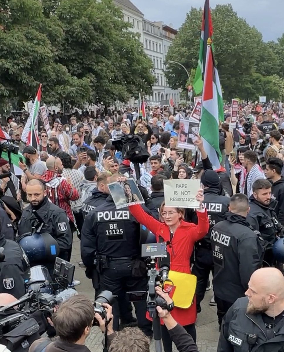 In Berlijn demonstreerden zaterdag zo’n 1500 mensen tegen Israel. In het gezelschap stond een politica vd FDP, #KarolinePreisler (in het rood gekleed) met in haar ene hand de foto vd door Hamas vermoorde Shani Louk en in de andere een bord ‘VERKRACHTING IS GEEN VERZET’. Preisler,
