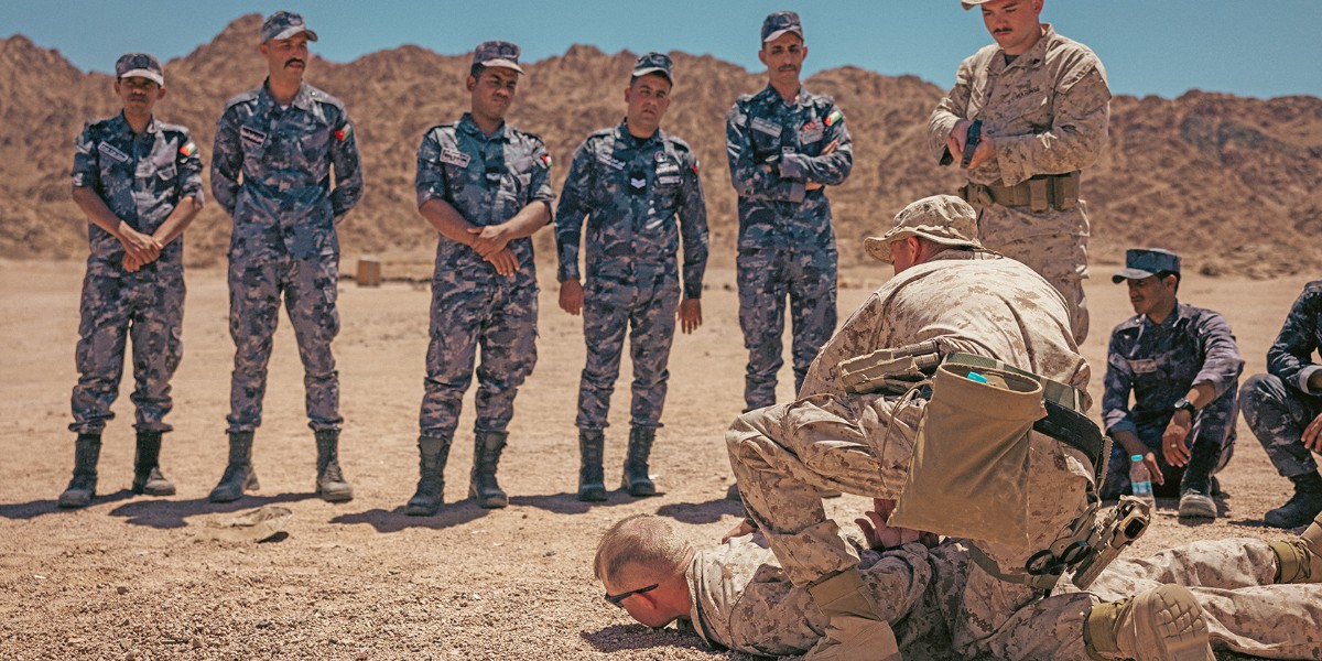 U.S. Marines from Company C, 4th Law Enforcement Battalion, demonstrate detaining techniques to Jordanian Armed Forces at Camp Titin, Jordan, on May 13, 2024, during Exercise Eager Lion 24, showing U.S. commitment to Middle Eastern partners in defense against hybrid threats.