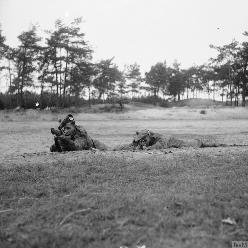 A sniper demonstrates the superior 'Hawkins' prone firing position (right) next to another in the standard position, at the 21st Army Group sniping school near Eindhoven, 15 October 1944. IWM (B 10972)