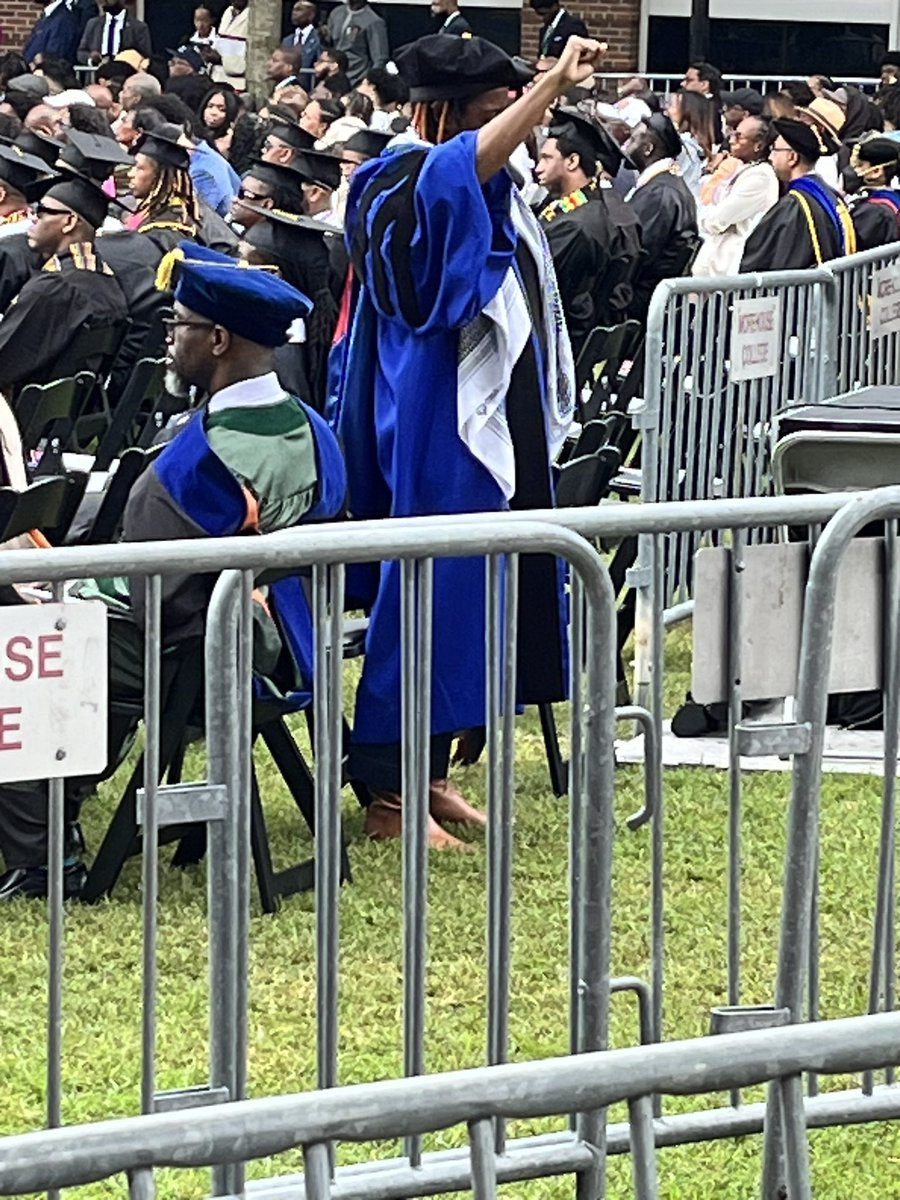 As Biden spoke at @Morehouse, at least one faculty member silently protested. Standing on the back row of the faculty section, she turned her back to the president while raising her right hand in a fist.