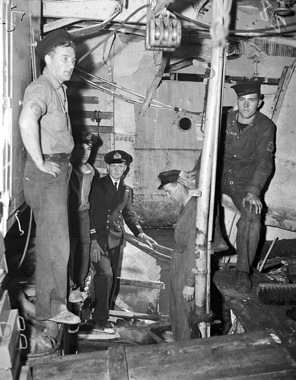 Personnel examining the damaged tiller flat of HMCS QU'APPELLE, England, 16 August 1944 (LAC a211858-v6) #RCN #History