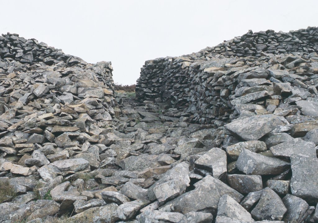 It's #HillfortsWednesday yes it is! Here's the NW inner gate of Tre'r Ceiri Hillfort, Llŷn Peninsula #Gwynedd THEN: in a reconstruction by A.Smith @GwyneddArch from @IntarchEditor intarch.ac.uk/journal/issue4… and NOW: @Toby_Driver1 © @RCAHMWales TGD001/01 coflein.gov.uk/en/site/95292/