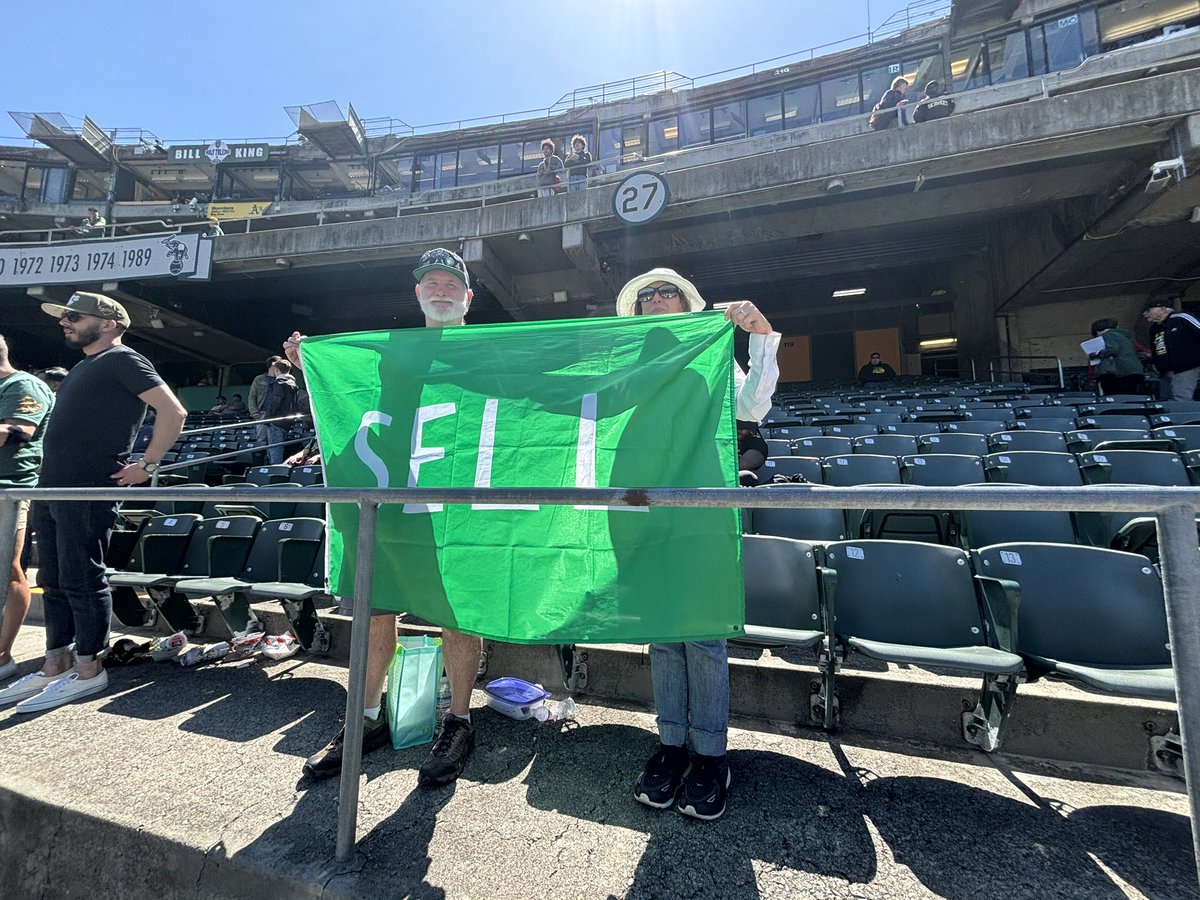 Update on that #SELL flag. Look at this adorable couple, how can you steal a sports team away from fans like this???!!! 💚💛💚💛 #oakland #selltheteam #rootedinoakland #FJF