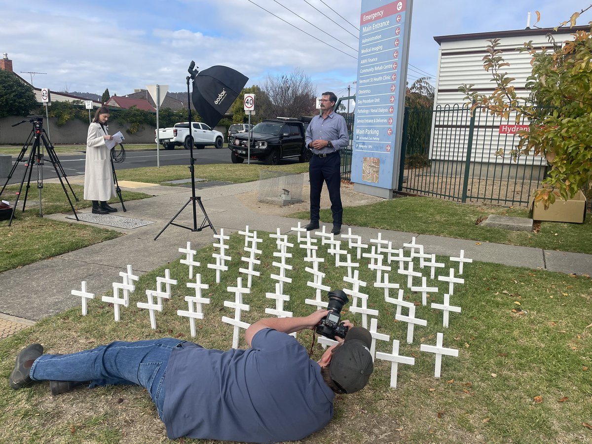 adbunn's tweet image. Benambra MP @billtilleymla being captured by Border Mail’s @james_photog with 68 crosses representing lives lost by patients on Albury Wodonga Health waiting list.