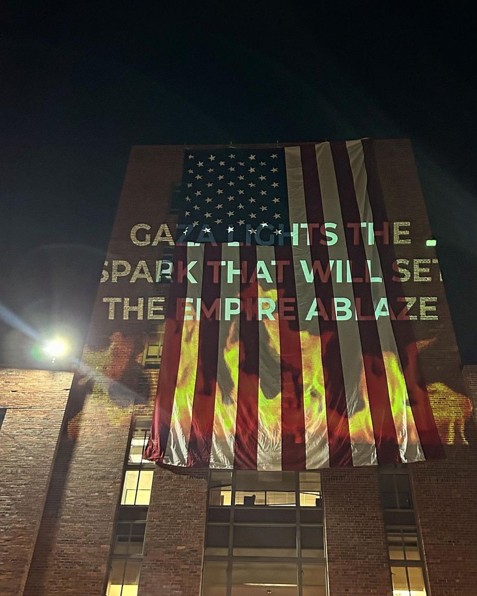 BREAKING: The George Washington University Encampment projects flames onto the American flag with text that reads... 'Gaza lights the spark that will set the empire ablaze'